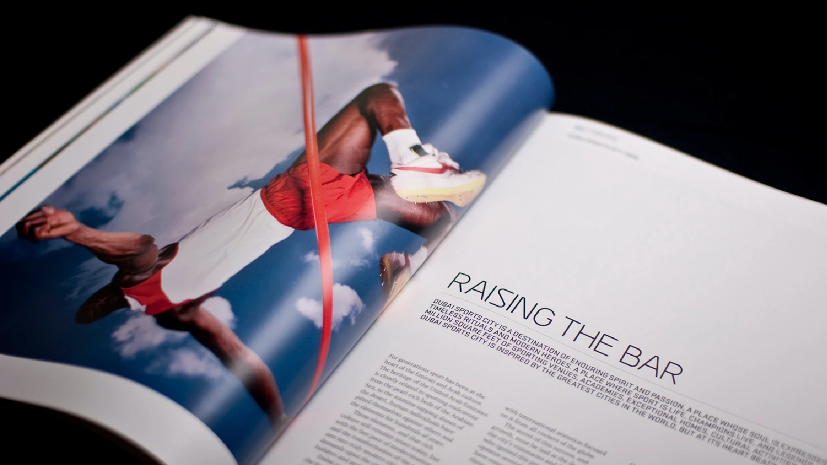 Dubai Sports City brochure spread titled Raising the Bar featuring athlete imagery
